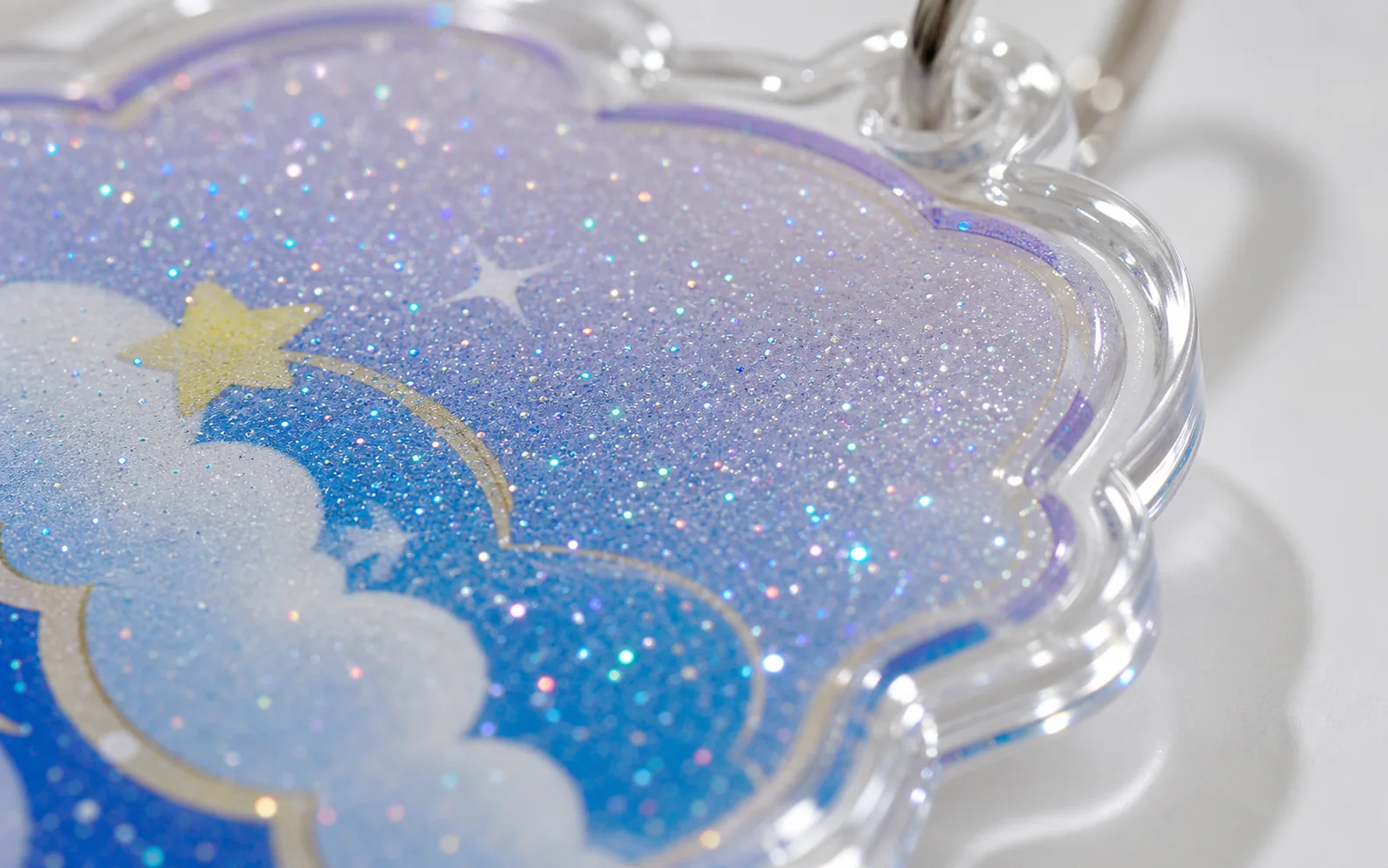 Close-up of a glitter-filled shaker charm with star and cloud artwork