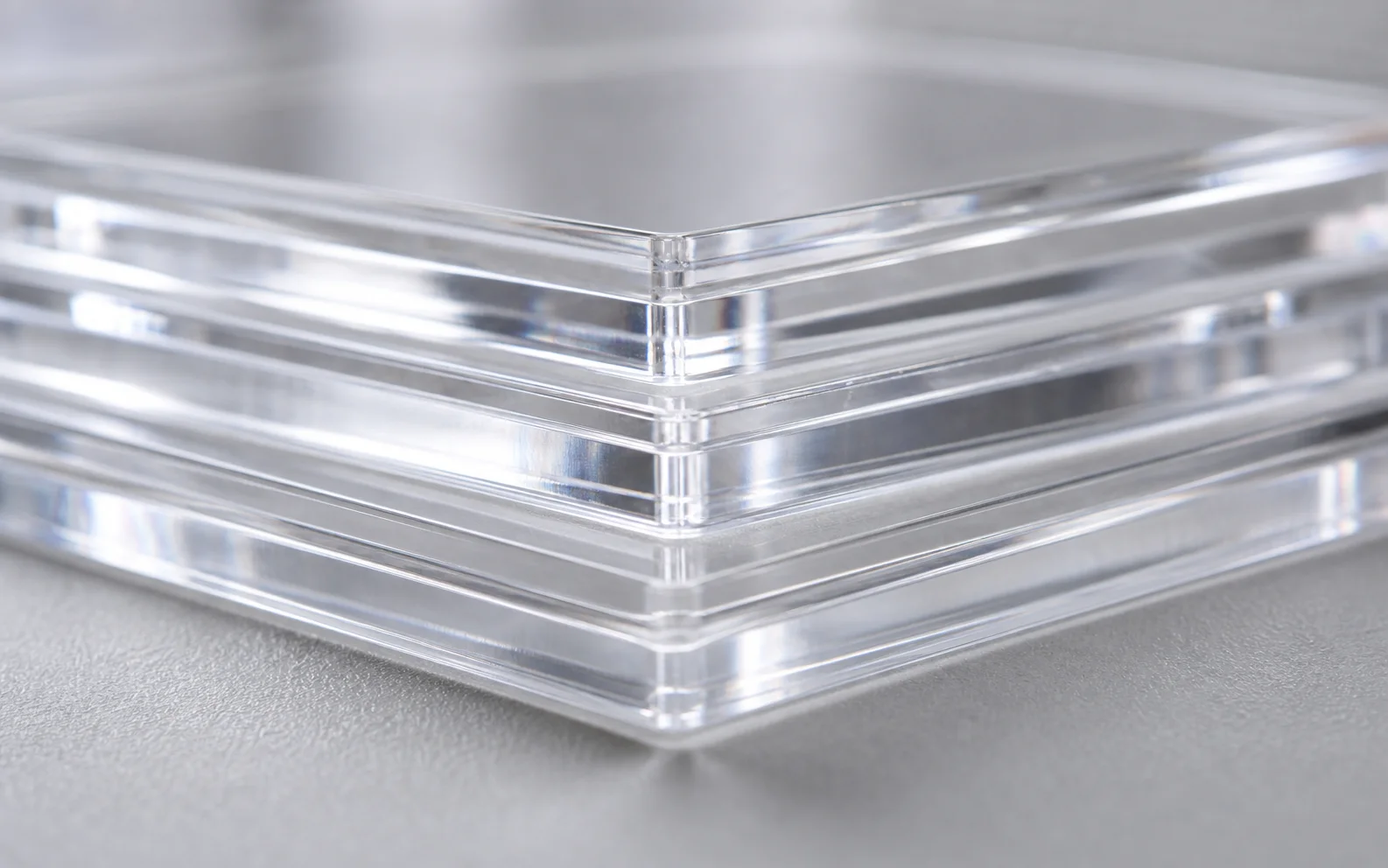 Close-up of stacked clear acrylic panels with polished square edges